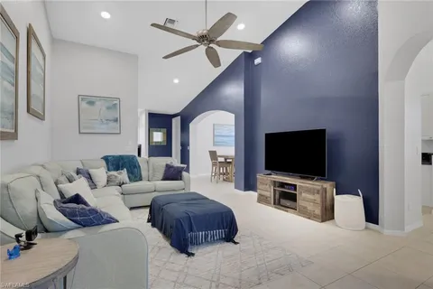 a living room with furniture a flat screen tv and kitchen view
