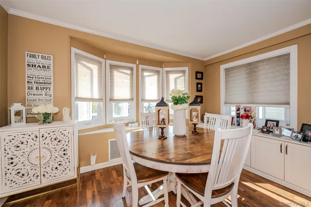 a dining room with furniture window and wooden floor