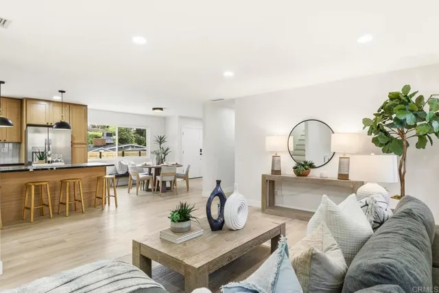 a living room with furniture a chandelier and a dining table