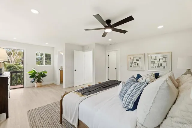 a spacious bedroom with a large bed and a chandelier