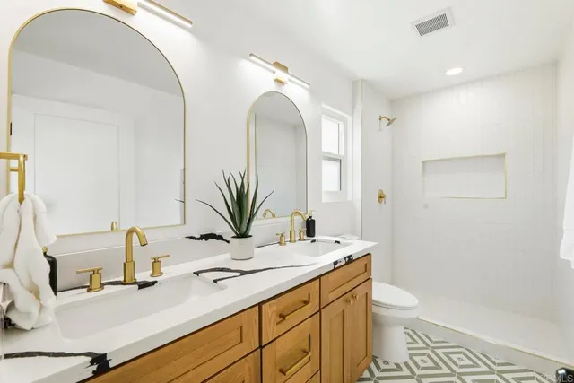 a bathroom with a granite countertop sink mirror vanity and toilet