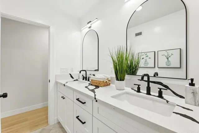 a bathroom with double vanity sinks and a mirror