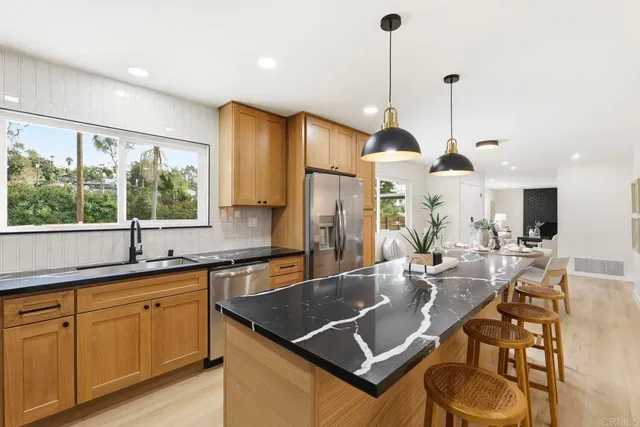 a kitchen with granite countertop a sink a stove and cabinets