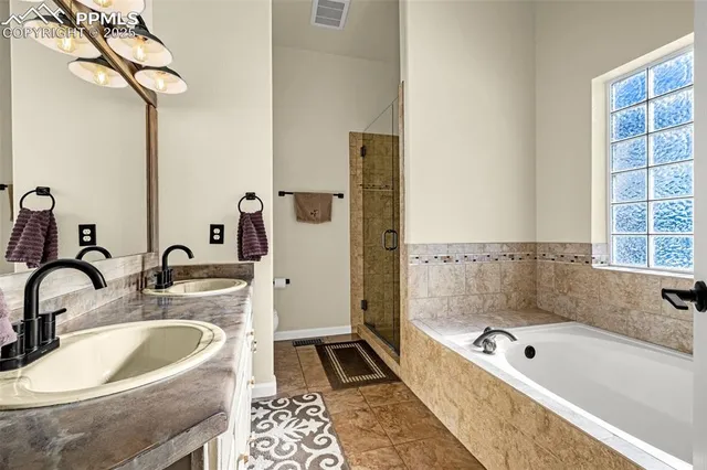 a bathroom with a tub a sink and a mirror