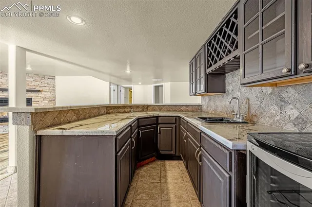 a kitchen with granite countertop a sink and a stove