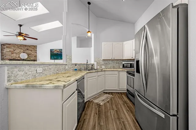 a kitchen with a refrigerator sink and cabinets