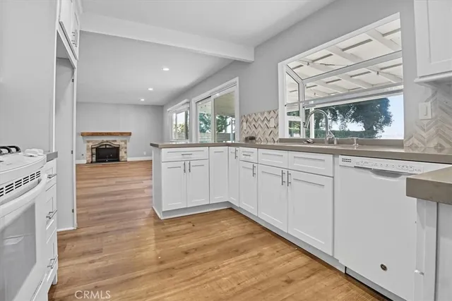 a kitchen with granite countertop white cabinets and white appliances