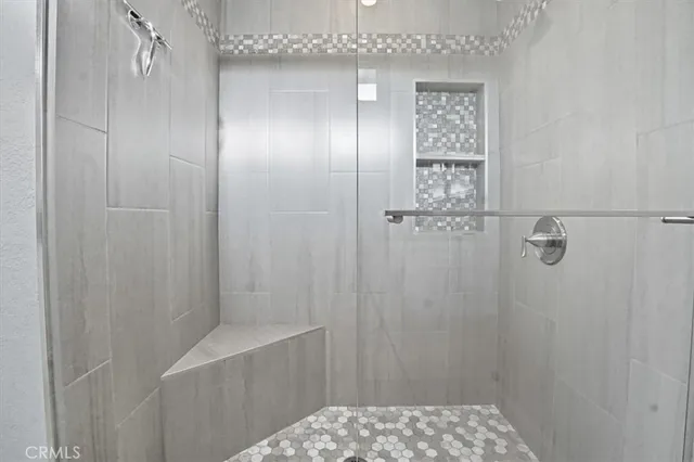 a bedroom with a large bed and windows