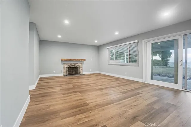 a big room with wooden floor and a fireplace