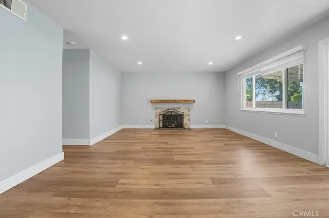 a big room with wooden floor and a window