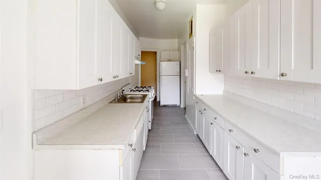 a kitchen with granite countertop white cabinets and sink