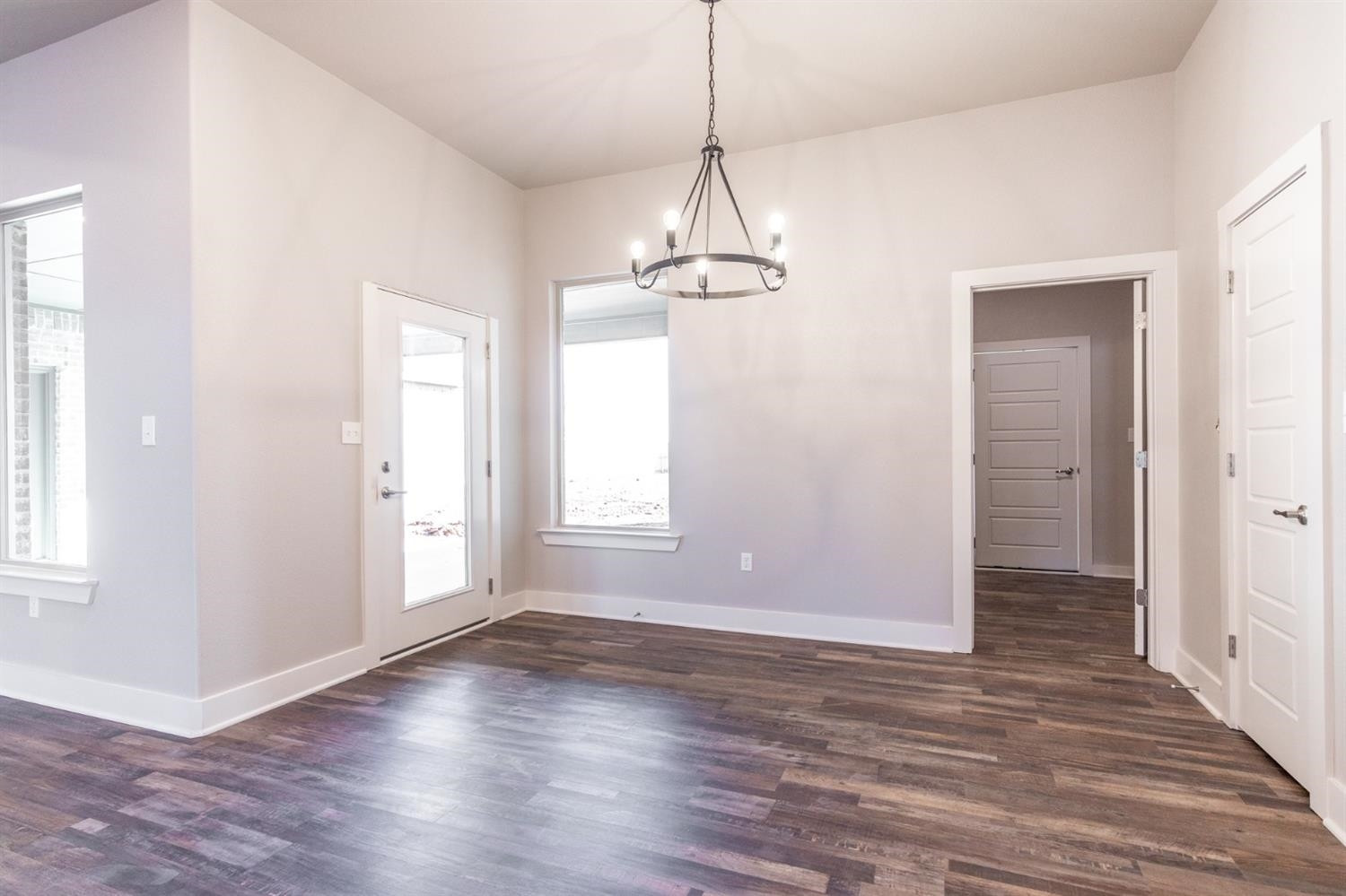 13311 Gardner Lubbock, TX 79424 - Photo 8 of 32 an empty room with wooden floor chandelier and windows