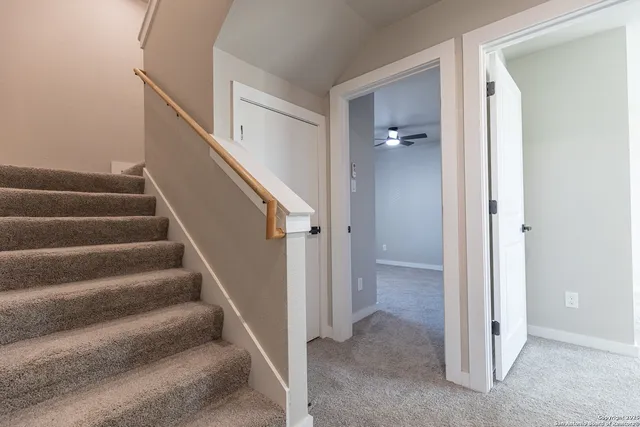 an empty room with a window and a fan