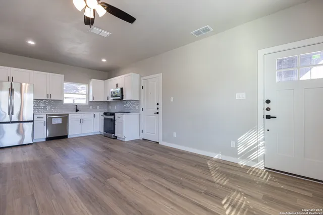 an empty room with wooden floor and windows