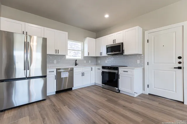 a kitchen with stainless steel appliances granite countertop a stove a sink and a microwave