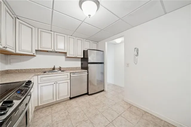 a kitchen with granite countertop white cabinets and stainless steel appliances