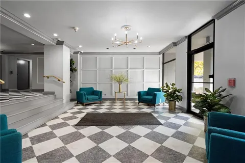 a view of a lobby with a rug and potted plants