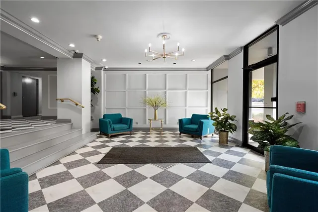 a view of a lobby with a rug and potted plants
