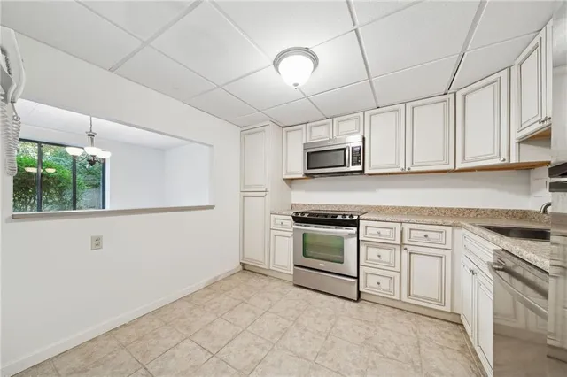 a kitchen with cabinets appliances and a window
