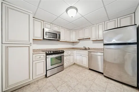 a kitchen with granite countertop white cabinets and white appliances