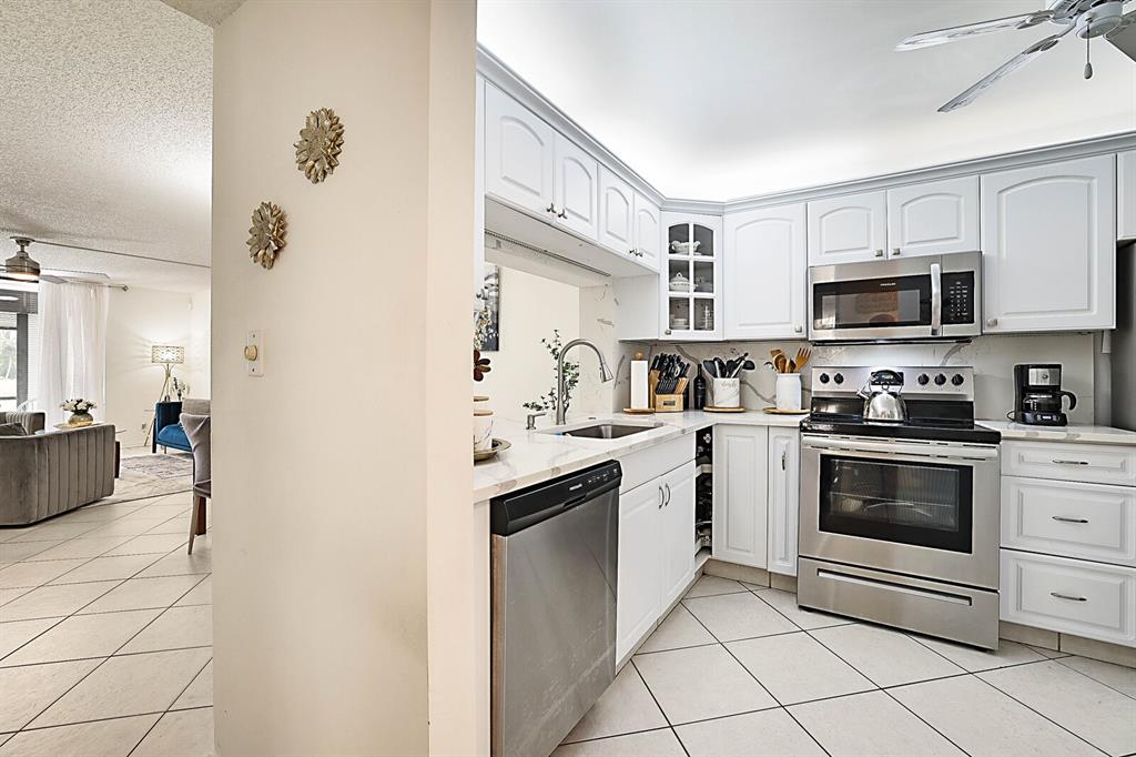 3485 Environ Boulevard, Unit C106 Lauderhill, FL 33319 - Photo 17 of 33 a kitchen with stainless steel appliances granite countertop a refrigerator and a stove top oven