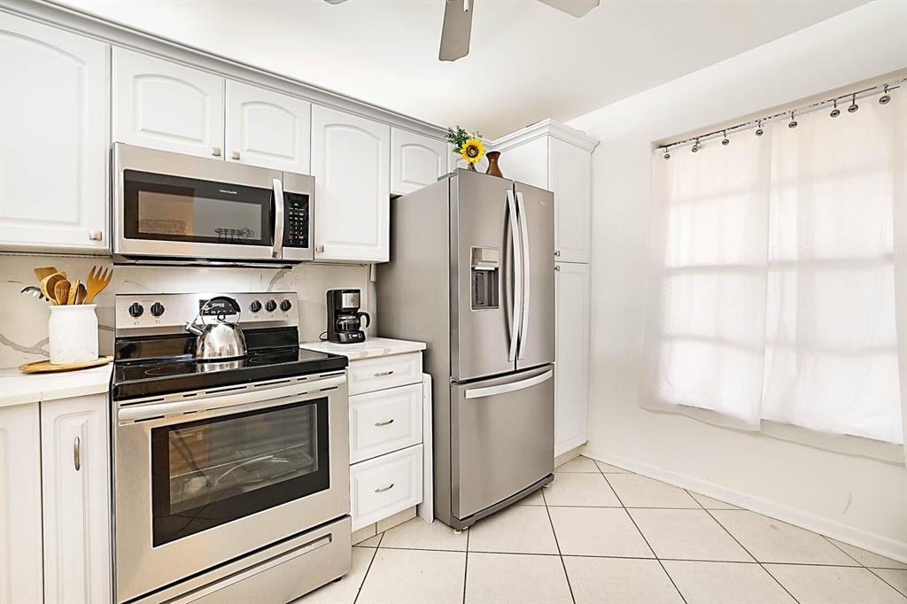3485 Environ Boulevard, Unit C106 Lauderhill, FL 33319 - Photo 8 of 33 a kitchen with granite countertop a refrigerator stove and microwave