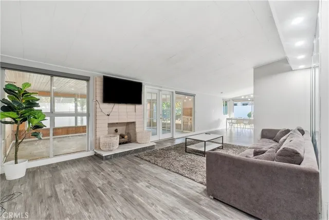 a living room with furniture a fireplace and a floor to ceiling window