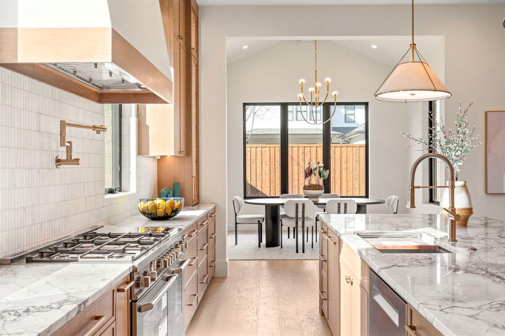 4231 Concho Street Dallas, TX 75206 - Photo 13 of 38 a kitchen with a stove a sink and a dining table in it
