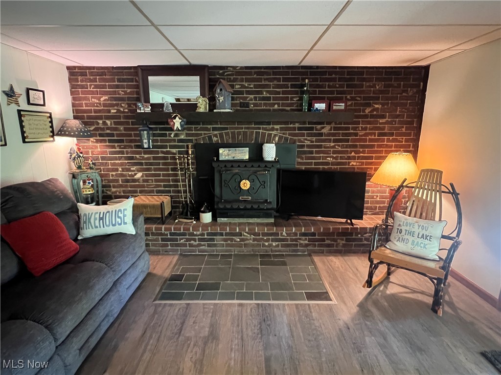 86422 North Bay Road Scio, OH 43988 - Photo 20 of 47 Living room featuring a brick fireplace, dark hardwood / wood-style flooring, and a drop ceiling