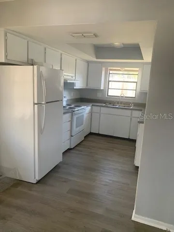 a kitchen with a refrigerator and a sink