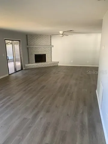 an empty room with windows and fireplace