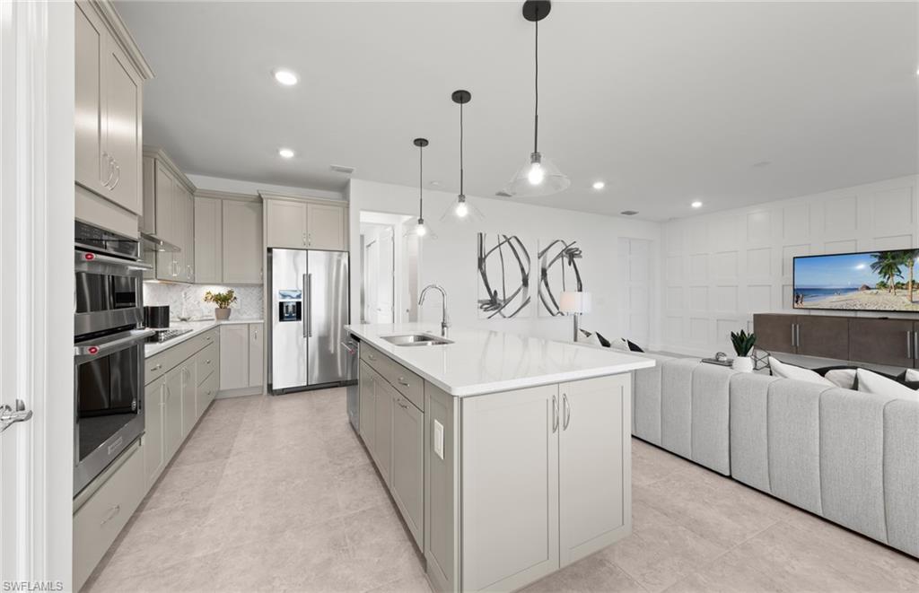 1879 Mesa Lane Naples, FL 34120 - Photo 4 of 24 a kitchen with white cabinets and stainless steel appliances