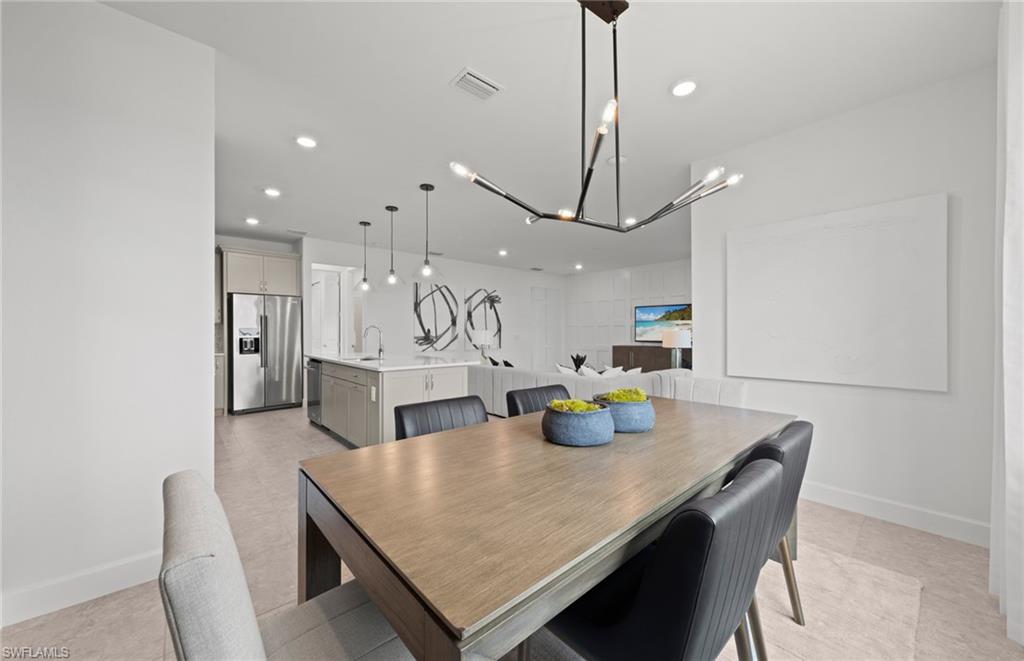 1879 Mesa Lane Naples, FL 34120 - Photo 6 of 24 a kitchen with stainless steel appliances a dining table chairs and white cabinets