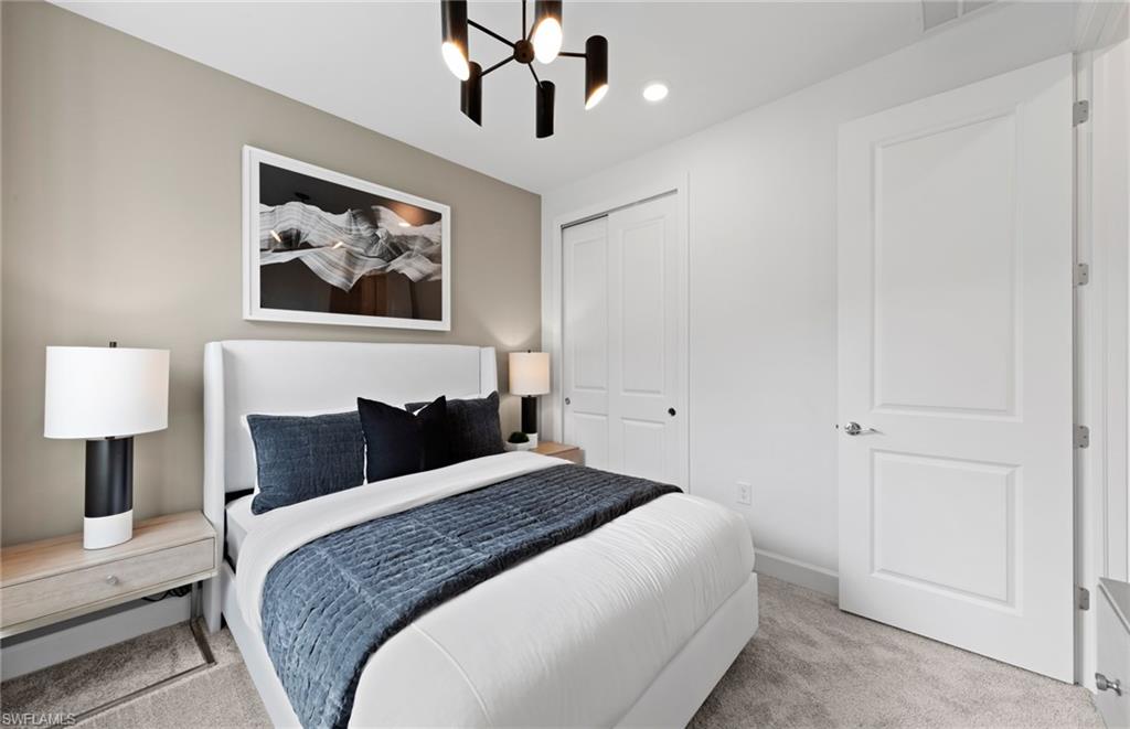 1879 Mesa Lane Naples, FL 34120 - Photo 10 of 24 a bedroom with a large bed and a chandelier