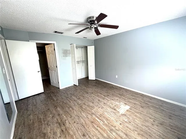 a view of empty room with wooden floor
