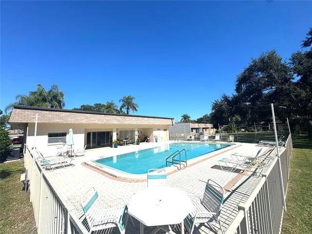 a view of a patio with table and chairs with wooden floor and fence