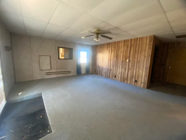 an empty room with windows and cabinet