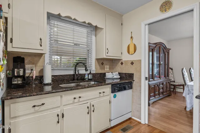 a kitchen with stainless steel appliances granite countertop a sink a stove and cabinets