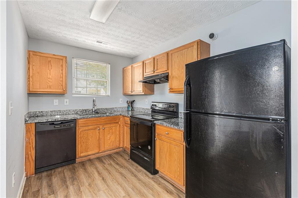 6536 Arbor Gate Drive Southwest, Unit 2 Mableton, GA 30126 - Photo 9 of 27 a kitchen with stainless steel appliances granite countertop a refrigerator a stove a sink and a microwave