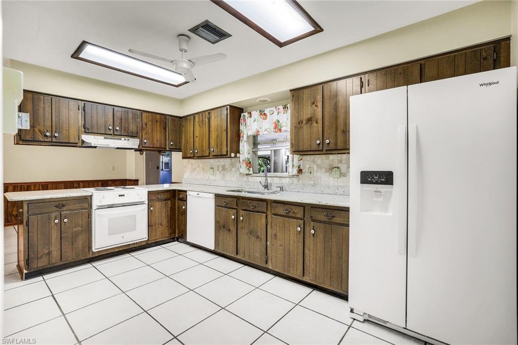 5290 Cypress Lane Naples, FL 34113 - Photo 11 of 35 a kitchen with white cabinets and white appliances