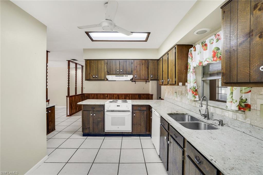 5290 Cypress Lane Naples, FL 34113 - Photo 12 of 35 a kitchen with a stove sink and cabinets