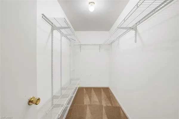 a view of an empty room and chandelier fan