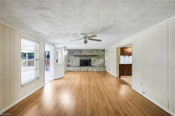 wooden floor fireplace and windows in an empty room