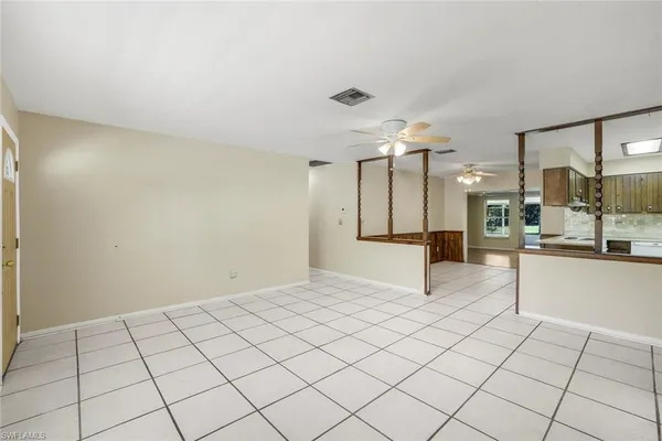 a view of a kitchen with kitchen island granite countertop a refrigerator and a stove top oven