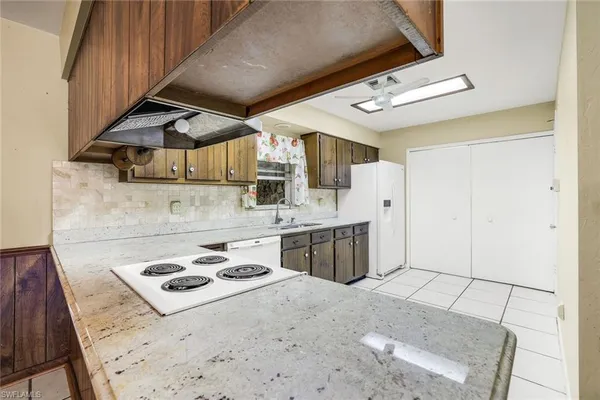 a kitchen with a stove a sink a refrigerator and cabinets