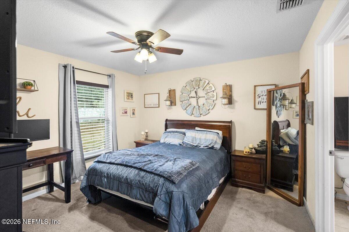 18 Pine Track Terrace Ocala, FL 34472 - Photo 12 of 23 a bedroom with a bed and a chandelier