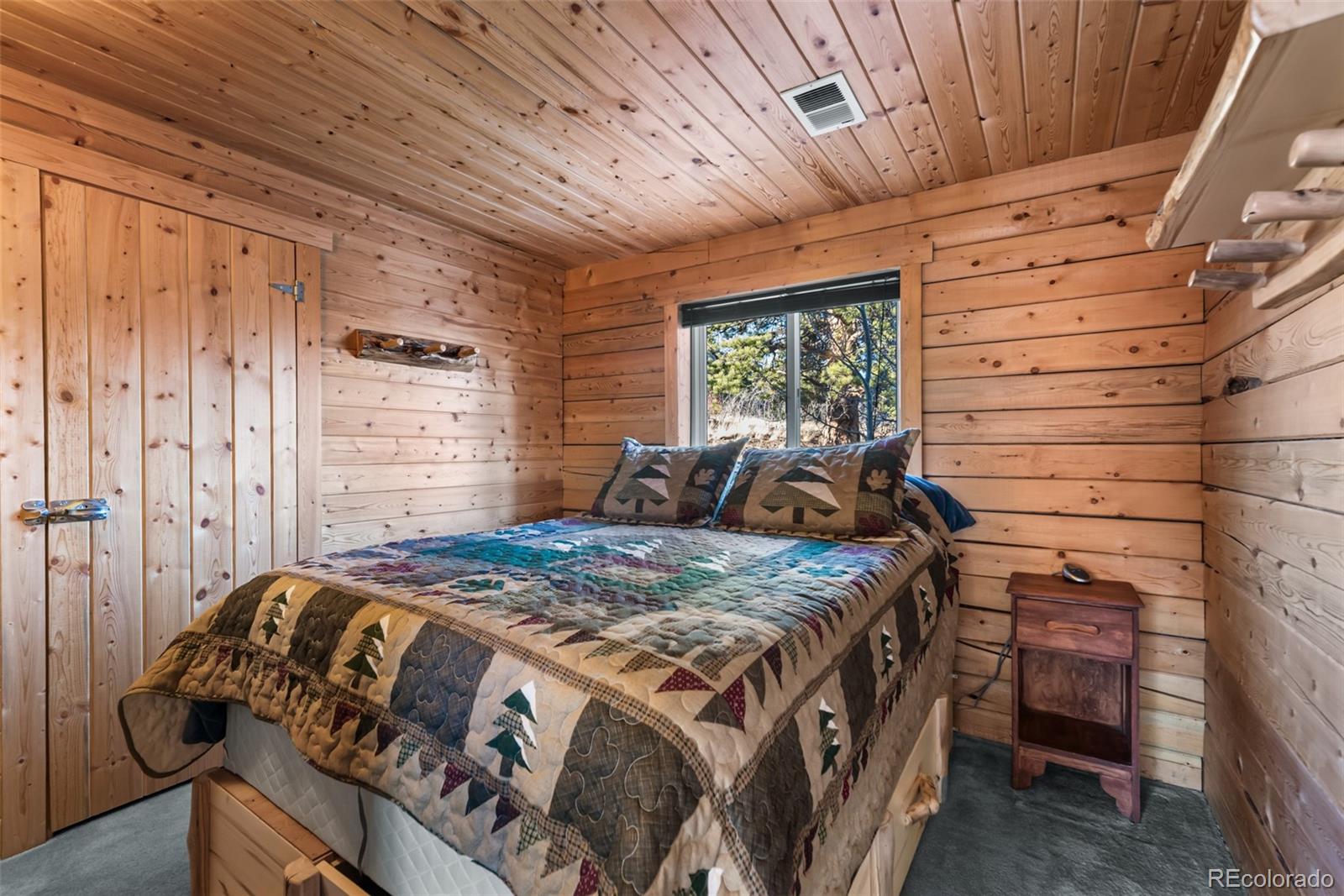 753 Teton Trail Como, CO 80456 - Photo 13 of 32 a bed sitting in a bedroom next to a window