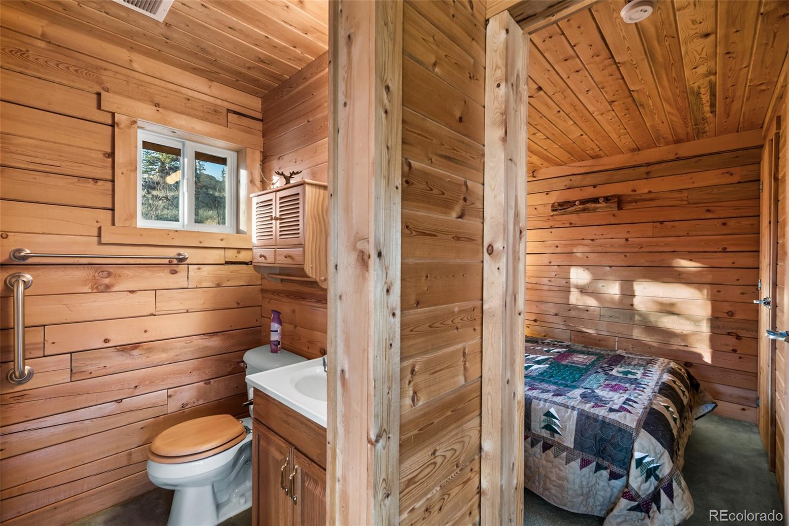 753 Teton Trail Como, CO 80456 - Photo 19 of 32 a bathroom with a toilet and a shower curtain