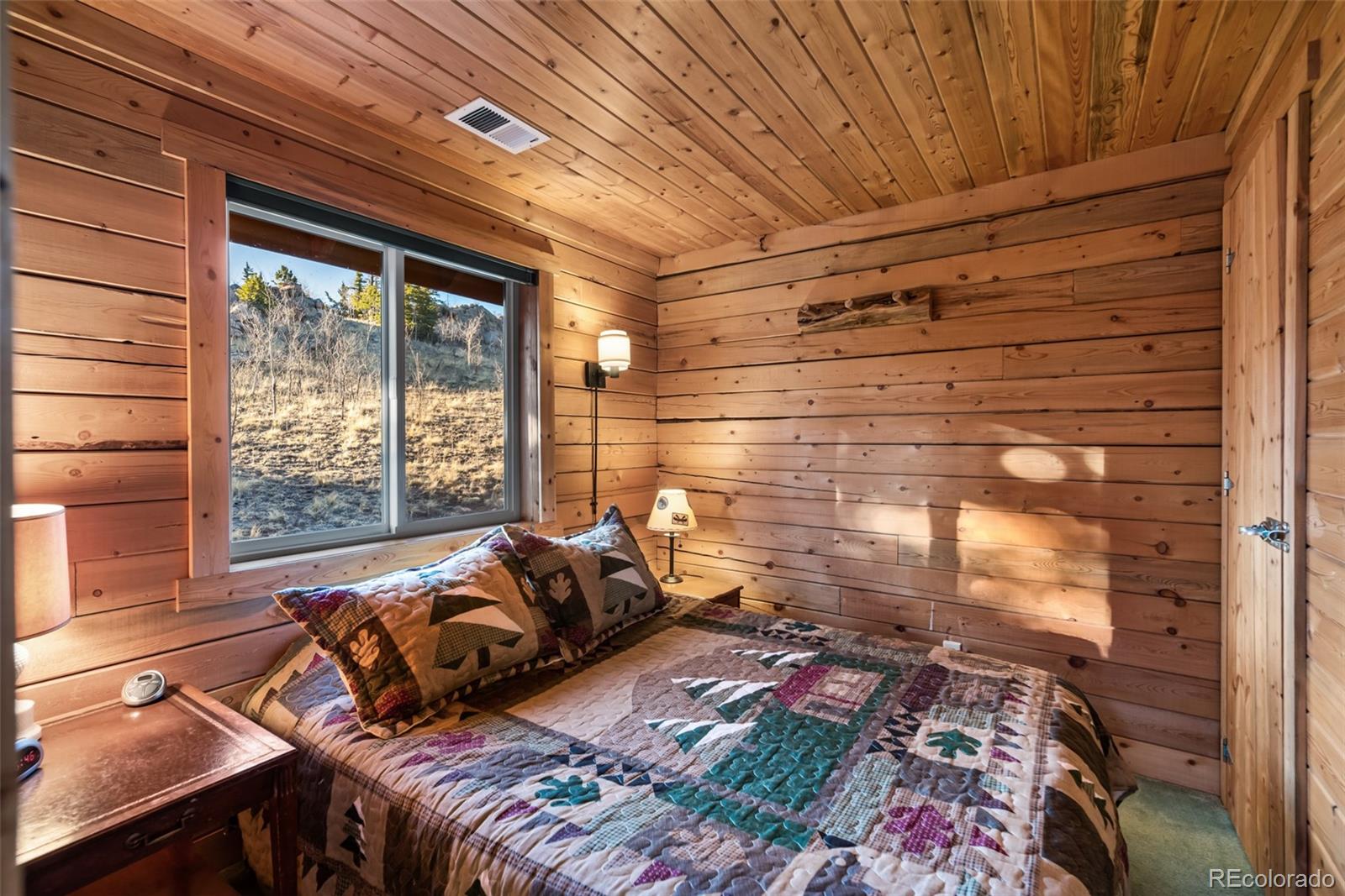 753 Teton Trail Como, CO 80456 - Photo 4 of 32 a bed sitting in a bedroom next to a window