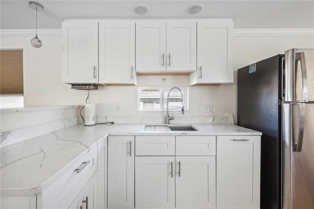 5307 Flint Street Zephyrhills, FL 33542 - Photo 14 of 63 a kitchen with a sink a refrigerator and cabinets